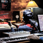 professional male music producer, composer working with guitarist in recording studio. music production concept